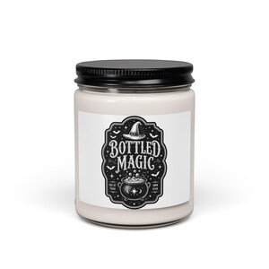 Peut inclure: Une bougie en pot de verre transparent avec un couvercle en métal noir, remplie de cire blanc cassé. L'étiquette présente une illustration en noir et blanc d'un chapeau de sorcière, d'un chaudron bouillonnant et de chauves-souris.