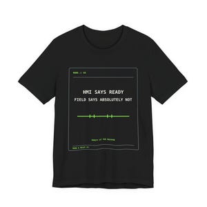 May include: A black short-sleeve t-shirt featuring a white and neon green graphic print. The design includes a rectangular border with the text HMI SAYS READY FIELD SAYS ABSOLUTELY NOT, a horizontal line with tick marks, and RUNG & RELAY CO.