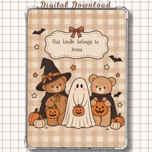 Op de afbeelding: Een digitale download met een beige gingham achtergrond, twee bruine teddyberen en een geest. De beren dragen heksenhoeden en capes en houden pompoenen vast. Een label bovenaan bevat de tekst, This kindle belongs to Jenna, met vleermuizen en sterren.
