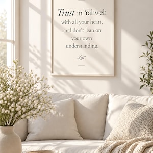 May include: A rectangular wall art print in a light-coloured frame featuring the black text "Trust in Yahweh with all your heart, and don't lean on your own understanding." and "PROVERBS 3:5" with a small botanical line drawing at the bottom.