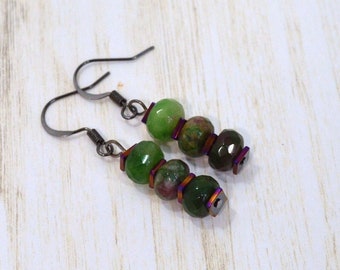 May include: A pair of dangle earrings with green and purple gemstone beads and silver-toned metal accents.