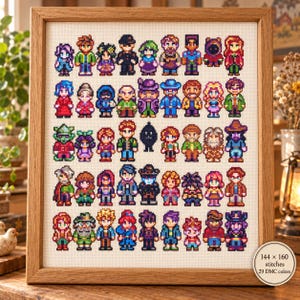 May include: A framed cross-stitch artwork featuring a grid of pixelated characters in various colorful outfits. A circular label in the corner displays the text 144 x 160 stitches and 29 DMC colors. The piece is enclosed in a light wood frame.