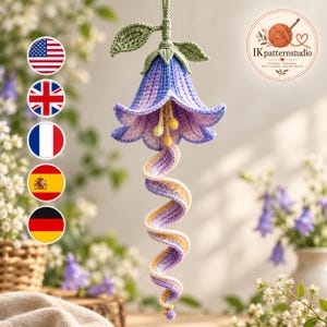 May include: A hanging crochet bellflower ornament in shades of purple and lavender with green leaves at the top and a long, spiraling tail. The design features yellow stamens and includes the text IKpatternstudio in the upper right corner.
