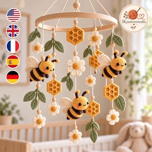 May include: A crochet baby mobile featuring three yellow and black bees, white flowers with yellow centres, green leaves, and yellow honeycomb shapes suspended from a circular wooden frame with small wooden beads on white strings.