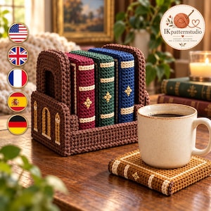 Puede incluir: Un soporte de ganchillo marrón con forma de estantería que contiene tres posavasos con forma de libro en color burdeos, verde oscuro y azul. Un posavasos a juego de color tostado sostiene una taza de cerámica color crema con motas.