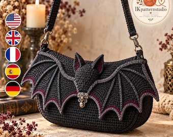 May include: A black crocheted shoulder bag shaped like a bat with extended wings, pointed ears, and a metallic clasp. The bag features dark purple trim along the wing edges and a matching black crocheted strap attached with antique-style metal hardware.