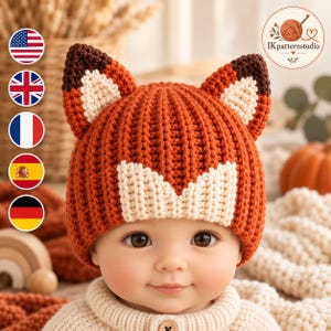 May include: A rust-orange and cream-colored crochet beanie featuring two pointed fox ears on top. The hat has a ribbed texture with a cream-colored V-shaped detail on the front. The logo IKpatternstudio is visible in the upper right corner.