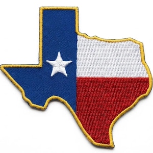 Puede incluir: Un parche bordado con la forma del estado de Texas que presenta el diseño de la bandera estatal. El parche tiene una franja vertical azul con una estrella blanca, una franja horizontal blanca y una franja horizontal roja, bordeadas con hilo amarillo.
