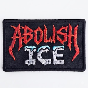 Könnte beinhalten: Ein rechteckiger, bestickter Aufnäher mit schwarzem Hintergrund und schwarzem Rand. Der Text ABOLISH ist in einer gezackten, roten Schrift im Metal-Stil gestickt. Darunter ist das Wort ICE in einer weißen, eisigen Schrift gestickt.