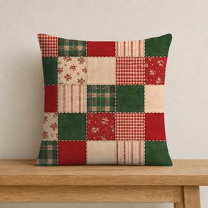 May include: A square throw pillow featuring a patchwork design of alternating fabric squares. The pattern includes solid red and green blocks, red and white gingham, green plaid, and cream fabric with small red floral prints.