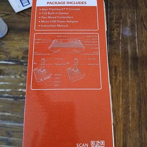 Puede incluir: Una caja de consola Atari Flashback 9 naranja con texto Plug N Play, una lista de 110 juegos integrados, dos mandos con cable, un adaptador de corriente micro USB y un manual. La caja incluye un diagrama de la consola y los joysticks.