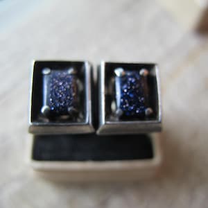 Peut inclure: Une paire de boucles d'oreilles en argent avec des pierres carrées bleu foncé serties dans des montures en argent.