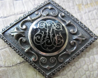 Zilverkleurige vintage broche kostuum mode pin. Echt vintage. Mode zilveren sieraden. Antieke stijl of look. Monogrambroche, Europees