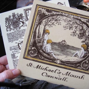 May include: An illustration of St. Michael's Mount in Cornwall, England. The image features a detailed drawing of the island with a castle on top, surrounded by water and trees. The text "St. Michael's Mount. Cornwall." is printed below the image.