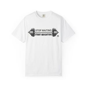 May include: A white short-sleeve t-shirt featuring a black graphic of a barbell centered on the chest. The text "STOP WAITING" is printed above the barbell bar, and "START WEIGHTING" is printed below it in a bold, sans-serif font style.