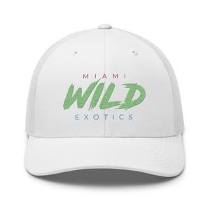 Könnte beinhalten: Eine weiße Trucker-Cap mit dem Text MIAMI in kleinen roten Buchstaben, dem Wort WILD in einer großen grünen Pinselstrich-Schriftart und dem Wort EXOTICS in kleinen blauen Buchstaben, zentriert auf der Vorderseite.