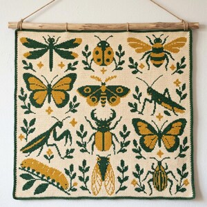 May include: A square crochet wall hanging featuring a grid of twelve insects including a dragonfly, ladybug, bee, butterflies, moth, grasshopper, mantis, beetle, caterpillar, and cicada in shades of forest green, mustard yellow, and cream.