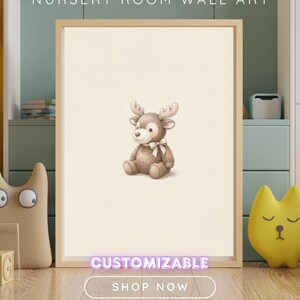 May include: A framed wall art print featuring a centered illustration of a brown cartoon reindeer with a white bow around its neck. The text NURSERY ROOM WALL ART, CUSTOMIZABLE, and SHOP NOW are visible on the image against a cream background.