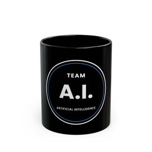 May include: A black ceramic mug featuring a circular graphic design with a thin blue and white border. The text inside the circle reads TEAM A.I. ARTIFICIAL INTELLIGENCE in white capital letters, centered against the solid black background of the mug.