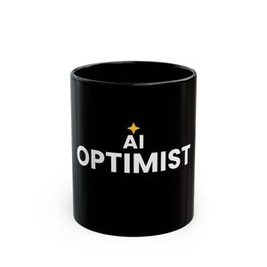 May include: A black ceramic mug featuring the white text AI OPTIMIST printed on the front. Above the text is a small, four-pointed yellow star icon. The mug has a smooth, glossy finish and a cylindrical shape with a flat base and open top.