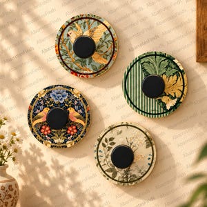 Può includere: Quattro ganci da parete circolari con distinti motivi botanici e aviari. Ogni gancio presenta un pomello centrale nero opaco montato su una piastra decorativa rotonda con disegni complessi di uccelli, fiori, foglie e motivi a righe.