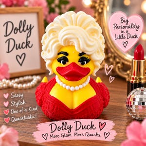May include: A yellow rubber duck figurine styled with a blonde bouffant wig, heavy black eyelashes, and a red beak. The duck wears a red lace-textured dress and a white pearl necklace. Text on the image includes Dolly Duck, Big Personality in a Little Duck, Sassy, Stylish, One of a Kind, Quacktastic, and More Glam. More Quacks.