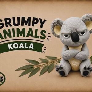 May include: A gray and cream-colored koala figurine with a grumpy facial expression and crossed arms. The text GRUMPY ANIMALS KOALA is printed in black and green, with an AMS logo in a circle. A green eucalyptus branch lies behind the figurine.