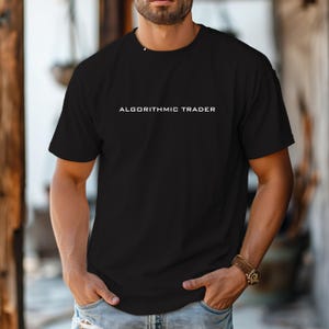 May include: A black short-sleeved t-shirt featuring the text ALGORITHMIC TRADER printed in white capital letters across the chest. The shirt has a crew neckline and a standard fit, providing a clean and simple look for casual daily wear.