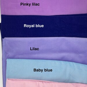 Pu&ograve; includere: Una collezione di sei campioni di tessuto piegati con una consistenza a coste. I colori sono etichettati come Aubergine, Pinky lilac, Royal blue, Lilac, Baby blue e Pink. Ogni pezzo di tessuto &egrave; impilato orizzontalmente, mostrando un colore solido.