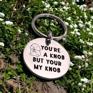 May include: A silver key chain with a round tag that says "You're a knob but your my knob". The tag has a small cartoon image of a knob.