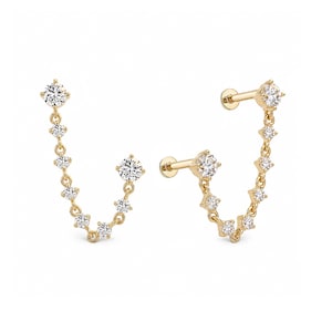 May include: A pair of gold chain earrings featuring a series of small, round, clear stones set in metal. Each earring consists of a flat-back post connected to a dangling chain of stones that loops back to a single stone stud at the other end.