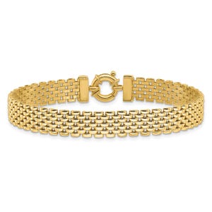 May include: A gold-colored bracelet with a woven design. The bracelet features a series of rectangular links connected to a circular clasp. The clasp has a decorative design. The bracelet is made of a shiny, metallic material.