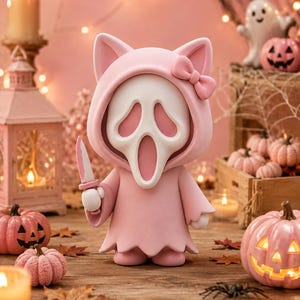 May include: A stylized figurine featuring a white ghost-like mask with a long, open mouth and hollow eyes, wearing a light pink hooded robe with cat ears and a small bow on the side, holding a small knife in one hand, rendered in a smooth finish.