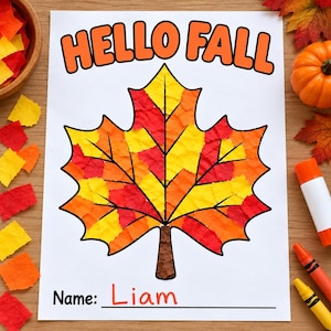 May include: A white craft paper sheet featuring the text HELLO FALL in orange letters at the top and a large maple leaf outline filled with textured yellow, orange, and red paper pieces. The bottom includes the text Name: Liam in orange.