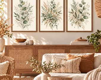 Könnte beinhalten: Ein Set aus drei gerahmten Wandbildern mit Aquarellillustrationen botanischer Arrangements aus Eukalyptusblättern, Farnen und getrockneten Gräsern in Salbeigrün, Beige und Creme auf einem hellen, cremeweißen Hintergrund.