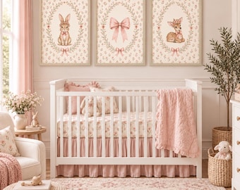 Könnte beinhalten: Drei rechteckige Wandbilder in hellen Holzrahmen mit einem Hasen, einer Schleife und einem Reh, jeweils in einem Blumenkranz. Die Bilder hängen über einem weißen Kinderbett mit einer rosa Steppdecke und blumiger Bettwäsche.