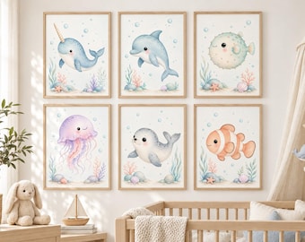 Könnte beinhalten: Ein Set aus sechs gerahmten Wandbildern mit Aquarellillustrationen eines Narwals, Delfins, Kugelfisches, einer Qualle, eines Seehunds und eines Clownfisches, umgeben von Blasen, Korallen und Muscheln auf hellem Grund.