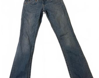 May include: A pair of blue denim jeans featuring a medium wash, a button and zipper fly closure, front pockets with copper-colored rivets, and visible stitching along the seams. The jeans have a straight-leg cut and a classic waistband.