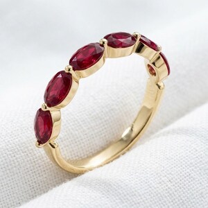 Bague en or 14 carats sertie de six rubis ovales rouges, bijou élégant et raffiné.