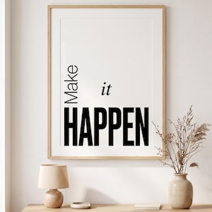以下が含まれることがあります： 白い背景に黒い文字で「Make it HAPPEN」と書かれた額装されたウォールアートプリント。明るい色の木製フレームに収められており、「Make」は縦書き、「it」は斜体、「HAPPEN」は太字で表示されています。