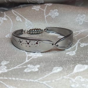 Armband gemaakt van oude Tide-lepels ingelegd met robijnrode kristallen.