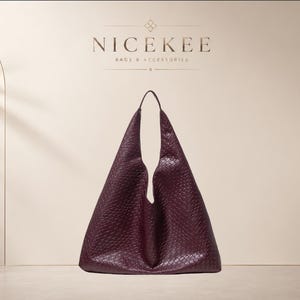 Peut inclure: Un sac hobo bordeaux profond avec une surface texturée et gaufrée. Le sac présente une poignée intégrée unique et une silhouette triangulaire souple. Au-dessus du sac, le texte NICEKEE BAGS & ACCESSORIES est affiché dans une police épurée.
