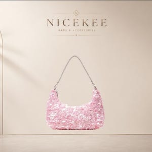 May include: A light pink hobo-style handbag covered in shimmering sequins. The bag features a curved silhouette and a thin, silver-toned metallic chain strap. Above the bag, the text NICEKEE BAGS & ACCESSORIES is displayed in dark lettering.