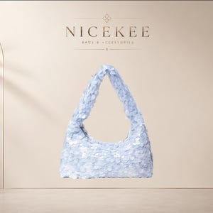 Peut inclure: Un sac à main de style hobo bleu clair recouvert de petites paillettes circulaires réfléchissantes. Le sac présente une bandoulière intégrée unique et une fermeture éclair. Au-dessus, le texte NICEKEE BAGS & ACCESSORIES est inscrit.