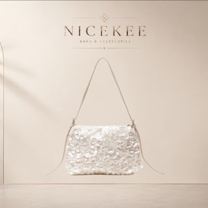 Pode incluir: Uma bolsa de ombro branca com lantejoulas, uma alça fina e fecho de correr. A bolsa está centrada sob o texto NICEKEE BAGS & ACCESSORIES, impresso numa fonte escura sobre um fundo claro. As lantejoulas criam uma superfície texturizada e brilhante.