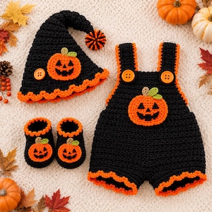 May include: A black crocheted baby outfit set consisting of a pointed hat with an orange pom-pom, a pair of booties, and overalls. Each piece features an orange jack-o'-lantern appliqué with a green stem and bright orange trim accents.