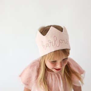 girl wearing embroidered crown with her name on it