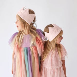 2 little girls wearing soft pink party crowns