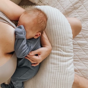 mom nursing a newborn on a breastfeeding pillow