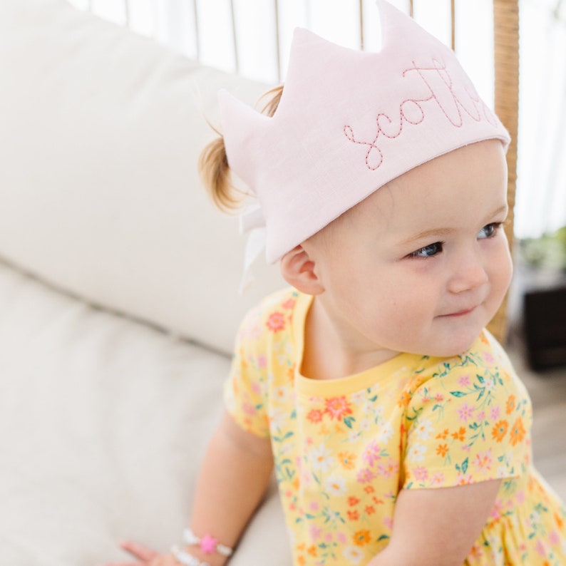 baby girl wearing a pink fabric birthday crown